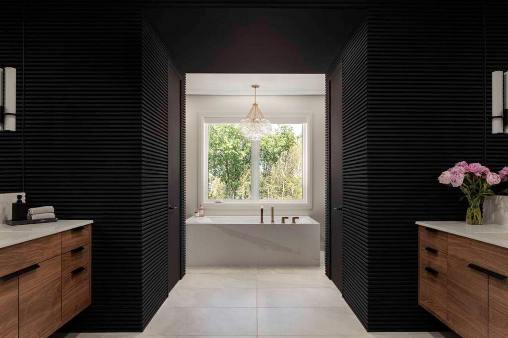 Luxurious Stone Design Concepts Gallery bathroom with a freestanding tub, dark wall accents, and a large window.