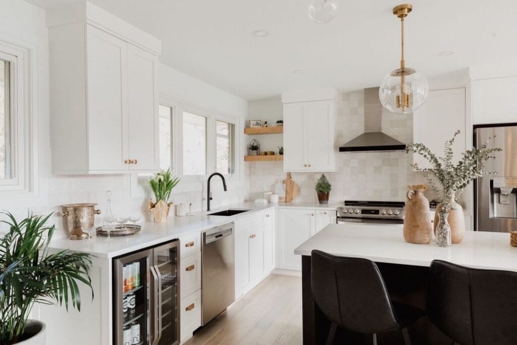 Open kitchen design from Stone Design Concepts Gallery with white cabinets, stainless steel appliances, and a farmhouse sink